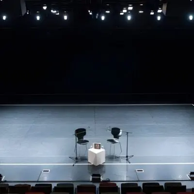 Darkened Empty Theater stage with two chairs in the center