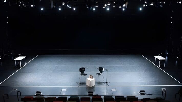 Darkened Empty Theater stage with two chairs in the center